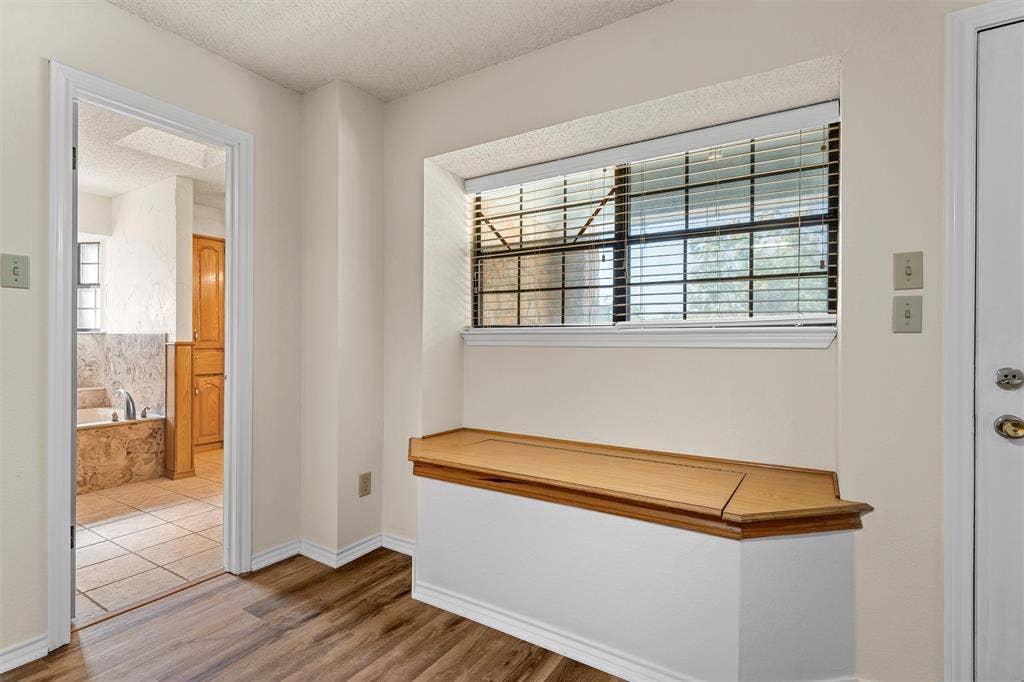 Primary bedroom entrance to bathroom and built in seating with storage
