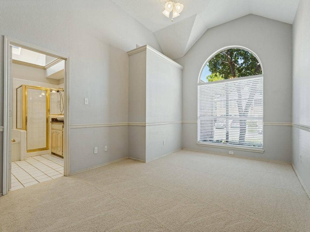 2206 Jasmine Lane, Garland, TX 75044 Vaulted ceiling with an arched window, neutral wall-to-wall carpeting, and a built-in light fixture