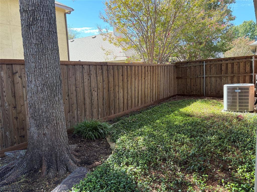 2206 Jasmine Lane, Garland, TX 75044 Private backyard featuring a full-perimeter wood fence, mature tree, patio and established ground cover.