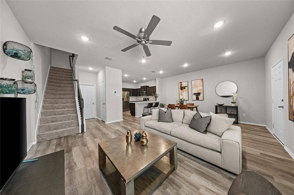 Open-concept interior featuring wood-finish flooring, recessed lighting, and a kitchen with an island