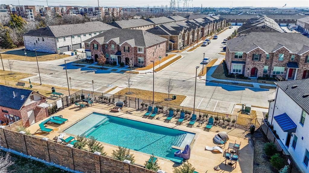 Community swimming pool featuring a concrete deck and a fenced perimeter