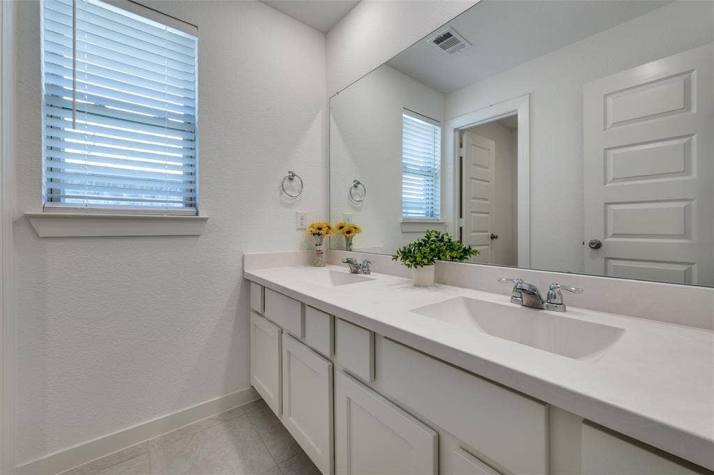 1520 Gelding Drive, Aubrey, TX 76227 Full bathroom with double vanity, a textured wall, and light tile patterned floors