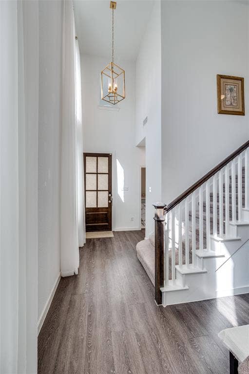 1520 Gelding Drive, Aubrey, TX 76227 Foyer entrance featuring wood finished floors, a towering ceiling, stairs, and a chandelier