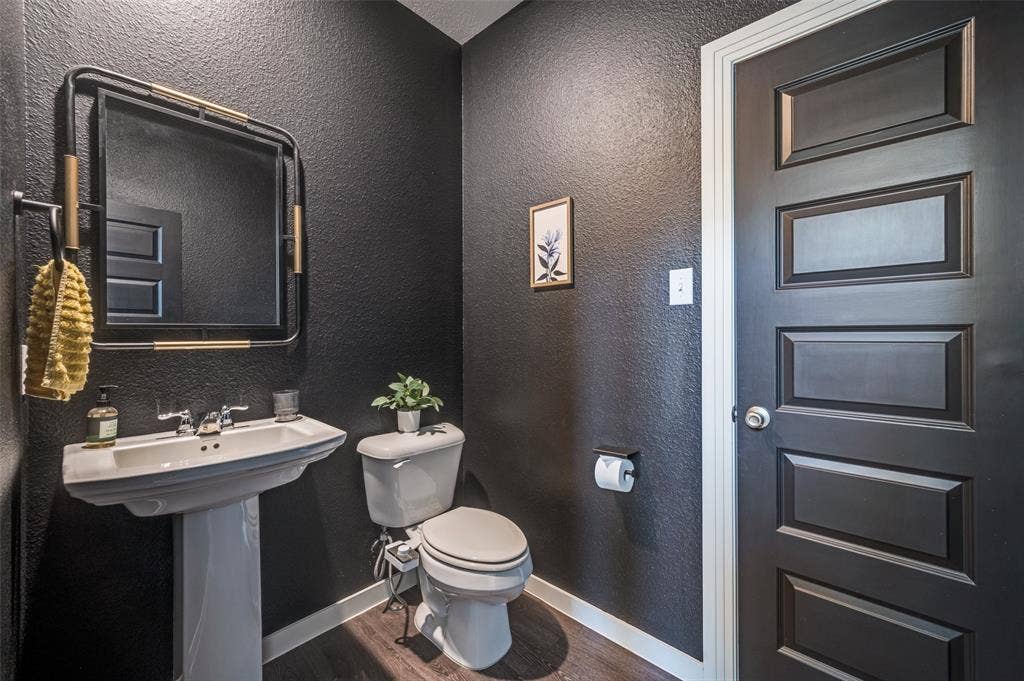 1520 Gelding Drive, Aubrey, TX 76227 Half bath with a textured wall and dark wood finished floors