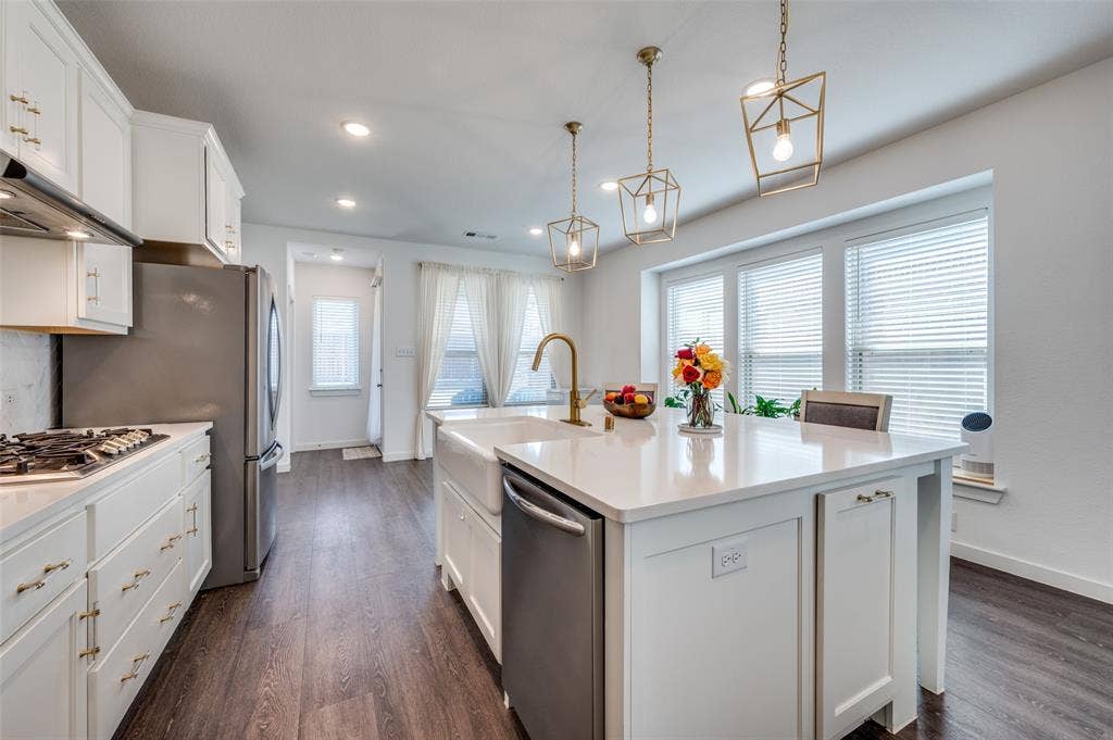 1520 Gelding Drive, Aubrey, TX 76227 Kitchen with white cabinetry, stainless steel appliances, pendant lighting, a center island with sink, and dark wood-style flooring