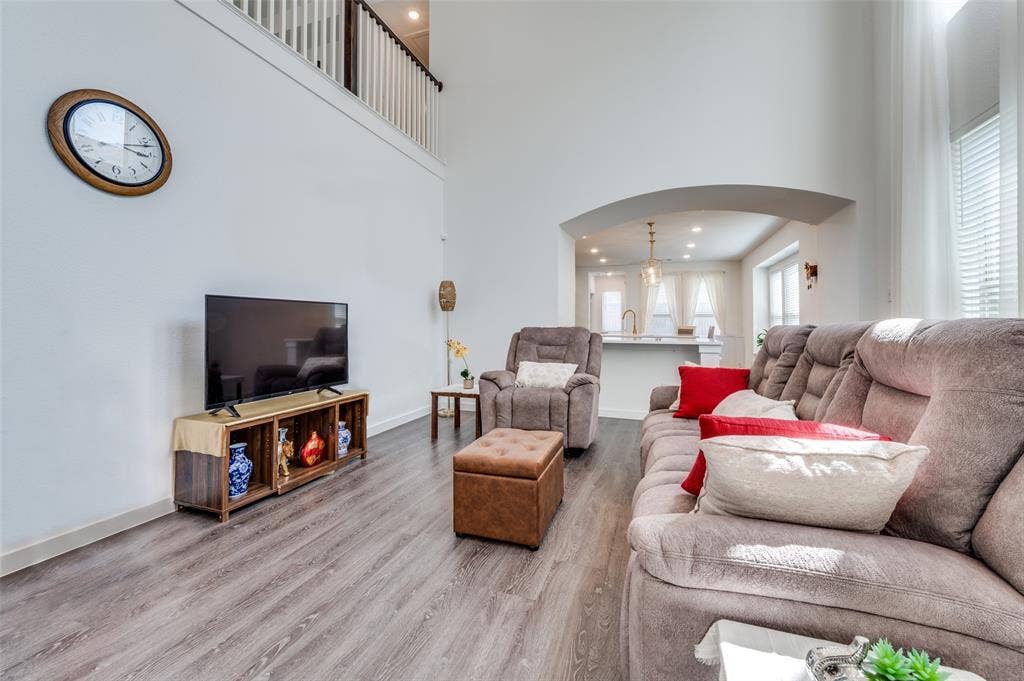 1520 Gelding Drive, Aubrey, TX 76227 Living area featuring arched walkways, wood finished floors, recessed lighting, and a high ceiling