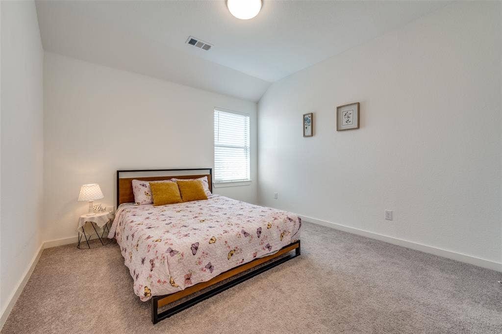 1520 Gelding Drive, Aubrey, TX 76227 Carpeted bedroom featuring lofted ceiling and baseboards