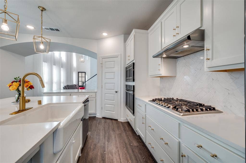 1520 Gelding Drive, Aubrey, TX 76227 Kitchen with pendant lighting, backsplash, white cabinetry, dark wood finished floors, and under cabinet range hood