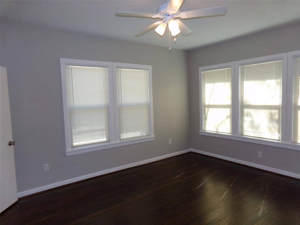 902 Centre Street, Dallas, TX 75208 Room featuring dark wood-finish flooring, multi-pane windows, and a ceiling-mounted light fixture with a fan