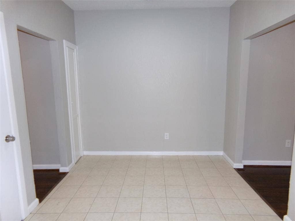902 Centre Street, Dallas, TX 75208 Neutral-toned interior space featuring light-colored ceramic tile flooring, solid-core doors, and recessed doorways