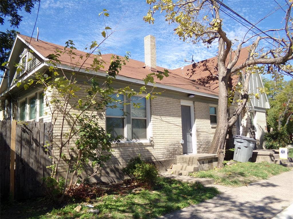 902 Centre Street, Dallas, TX 75208 Exterior featuring light-colored brick siding, a gable roof with shingle finish, and a central masonry chimney