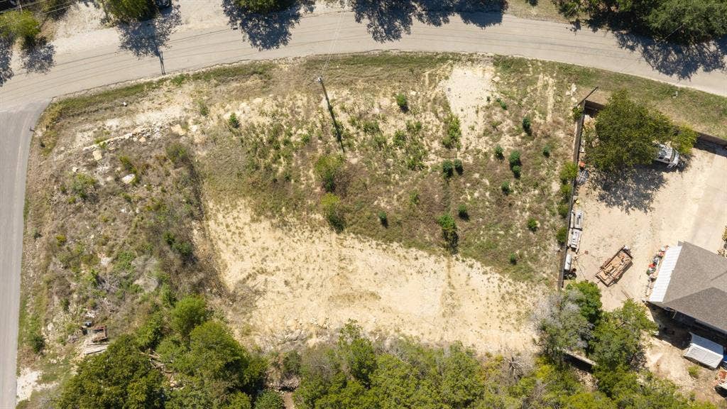 Corner lot featuring natural terrain, mature trees, and street access on two sides