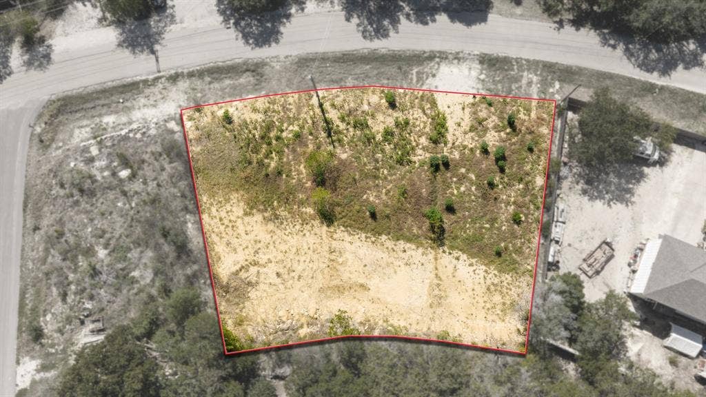 Interior  lot featuring a trapezoidal parcel of land with varied natural vegetation and established mature trees