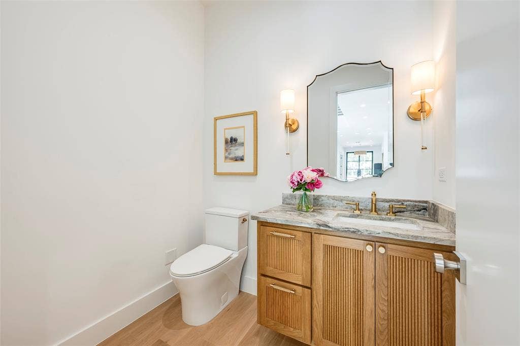 Powder bath off the living area with custom solid white oak fluted vanity and quartzite countertop.