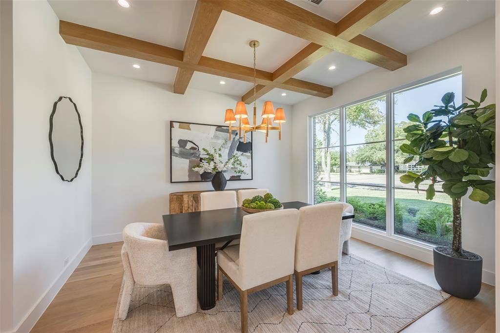 Light-filled dining room with white oak coffered ceiling and designer chandelier