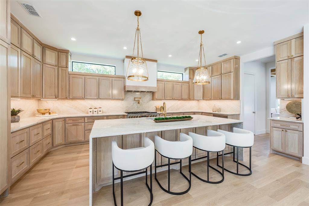 Oversized island with light Taj Majal countertop and matching backsplash