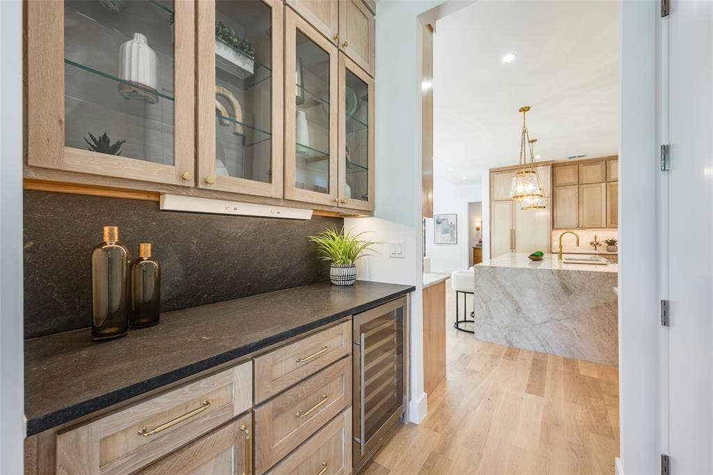 Butlers pantry with wine fridge and walk-in pantry separates dining room from kitchen.