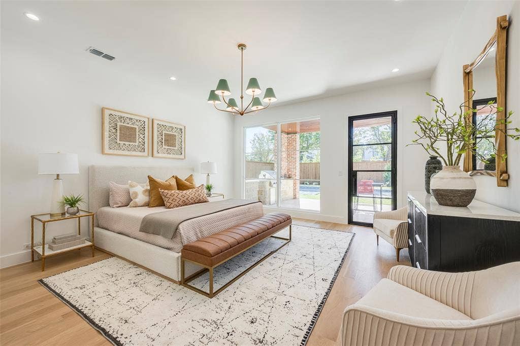 High ceilings, designer chandelier, wall of windows looking over patio & pool make this is an inviting primary suite!