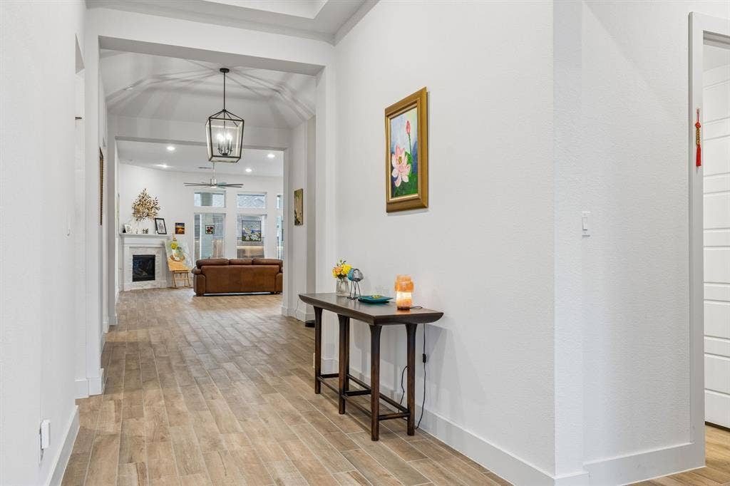 Entryway featuring wood-finish flooring, vaulted ceiling, and geometric lantern-style pendant lighting