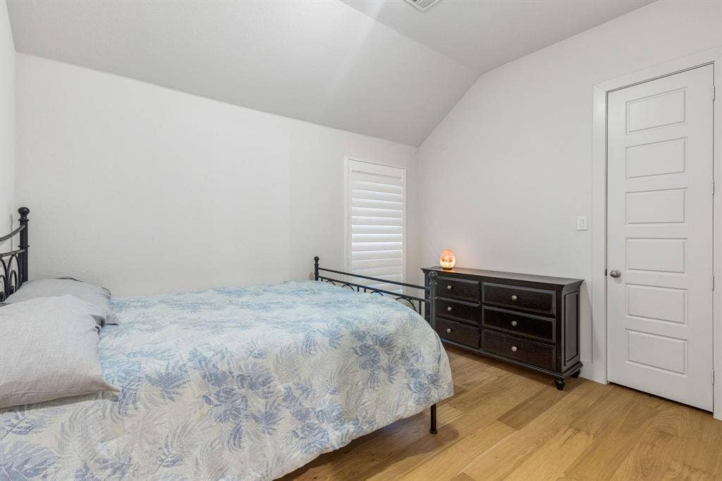 Vaulted ceilings, wood-finish flooring, and white plantation shutters