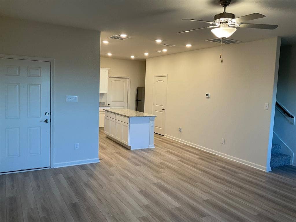 325 Stone Court, Princeton, TX 75407 Open-concept interior featuring wood-finish flooring, recessed lighting, a ceiling fan, and a kitchen island with stone-finish countertops