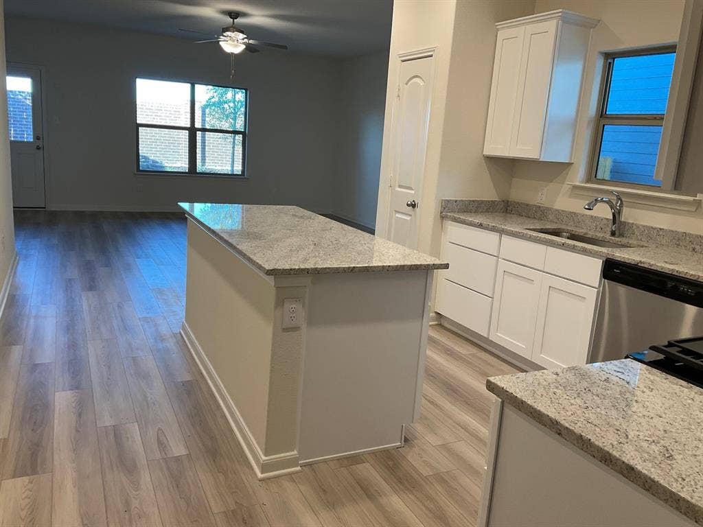 325 Stone Court, Princeton, TX 75407 Kitchen featuring white cabinetry, stone-finish countertops, a central island, and wood-finish flooring