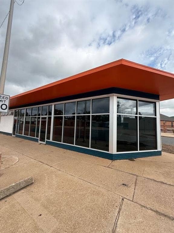218 N Market Street, Shreveport, LA 71107 expansive wrap-around storefront window system, prominent overhanging roofline, and durable siding