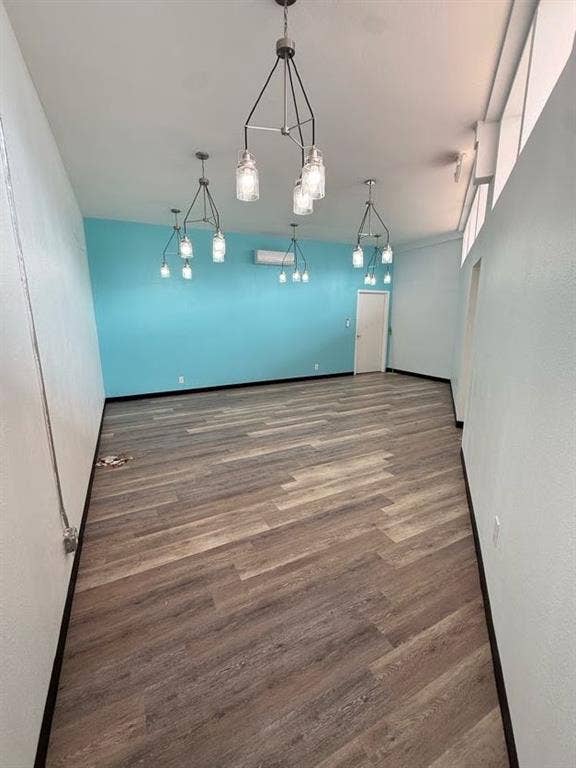220 N Market Street, Shreveport, LA 71107 Interior room featuring wood-finish flooring, vaulted ceilings with clerestory windows, and four multi-light metal chandeliers