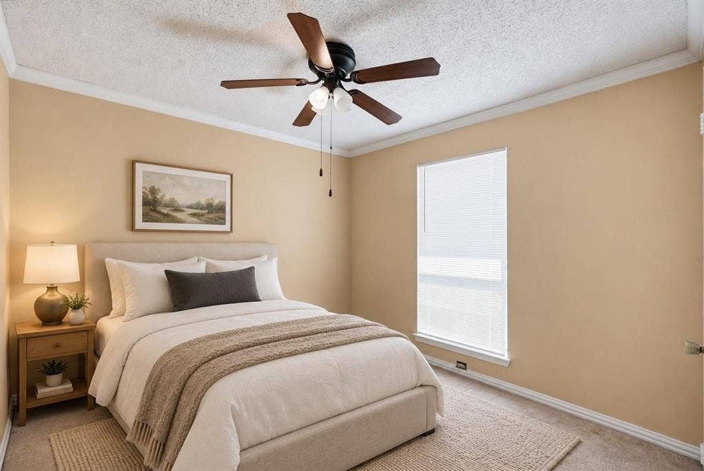 Room featuring a ceiling fan with integrated lighting, neutral wall paint, crown molding, and a tall window