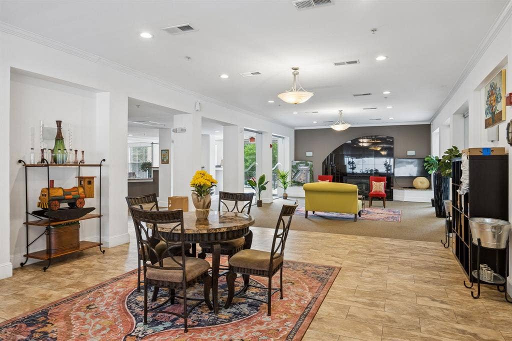 Spacious common area featuring light-toned tile flooring, recessed lighting, and multiple pendant light fixtures