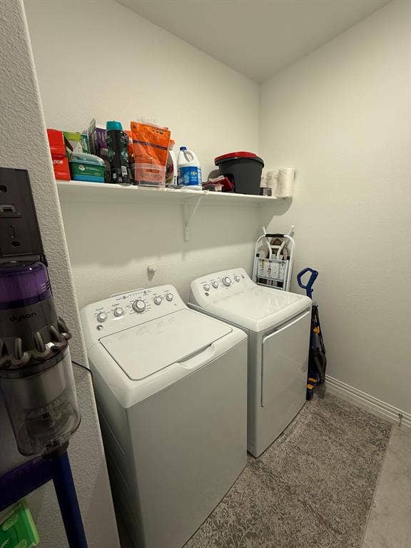 Laundry area with washer and dryer and a textured wall