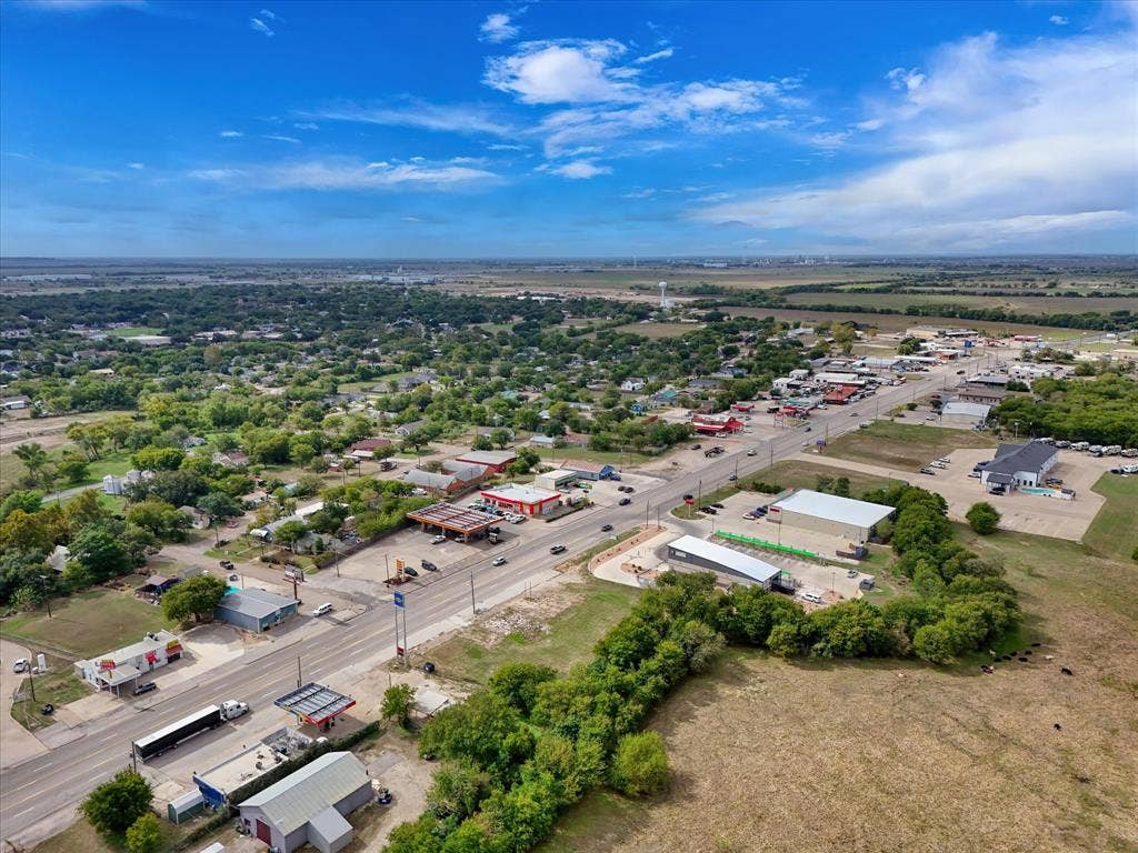 Aerial perspective showcasing high-visibility frontage along a primary thoroughfare with proximity to regional commercial infrastructure and expansive open acreage