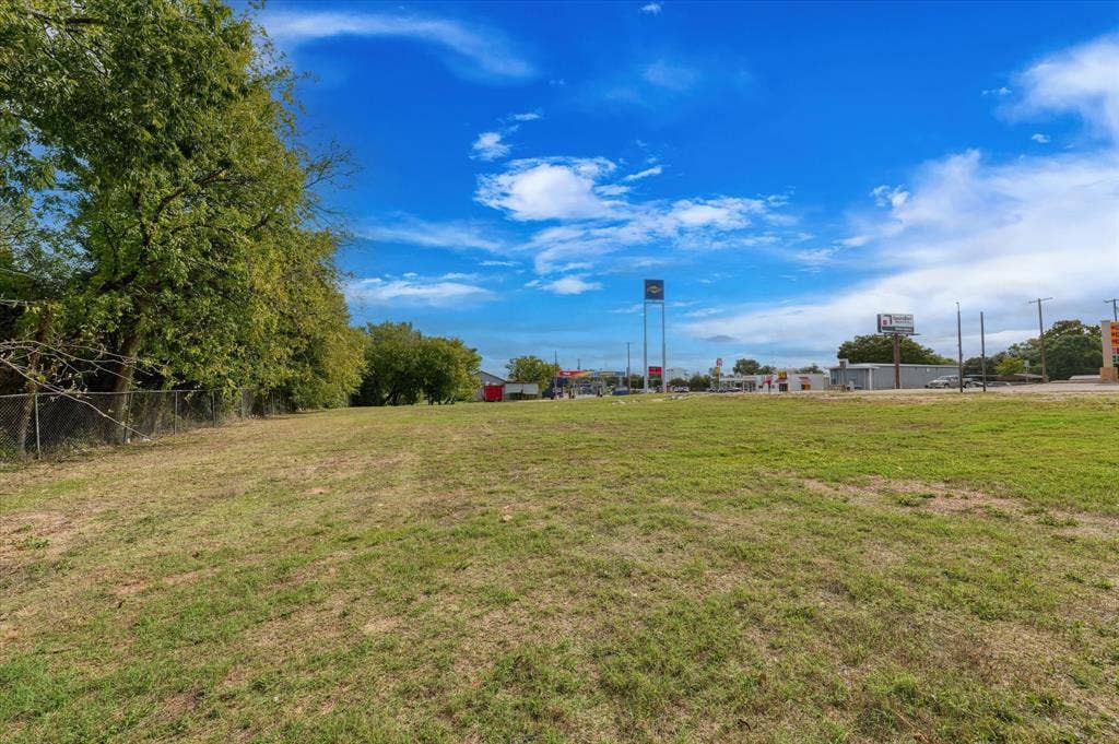 Expansive level lot featuring cleared grass terrain and mature perimeter trees