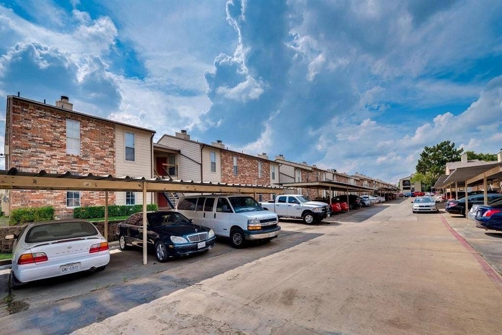12484 Abrams Road, Dallas, TX 75243 Exterior featuring brick and siding facade with metal-roofed carports