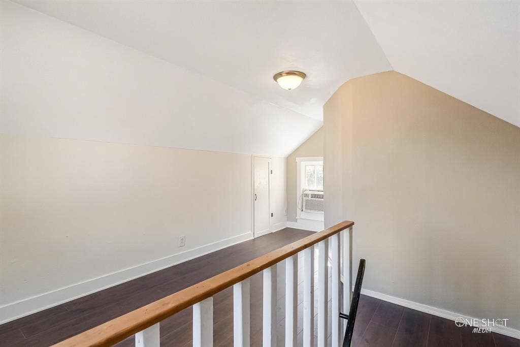 Corridor featuring cooling unit, dark hardwood / wood-style floors, and vaulted ceiling