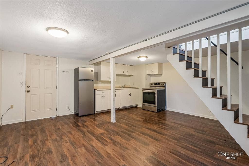 Kitchen with sink, dark hardwood / wood-style flooring, a textured ceiling, and appliances with stainless steel finishes