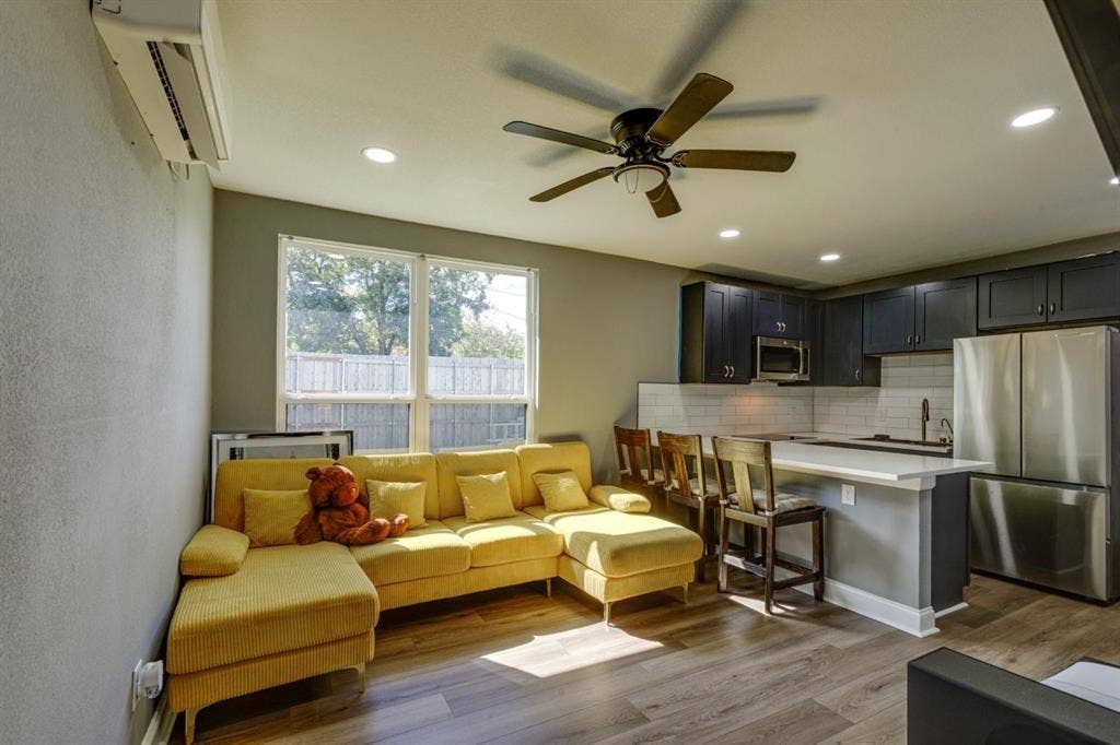 Kitchen featuring dark cabinetry, white tile backsplash, stainless steel refrigerator, recessed lighting, and wood-finish flooring