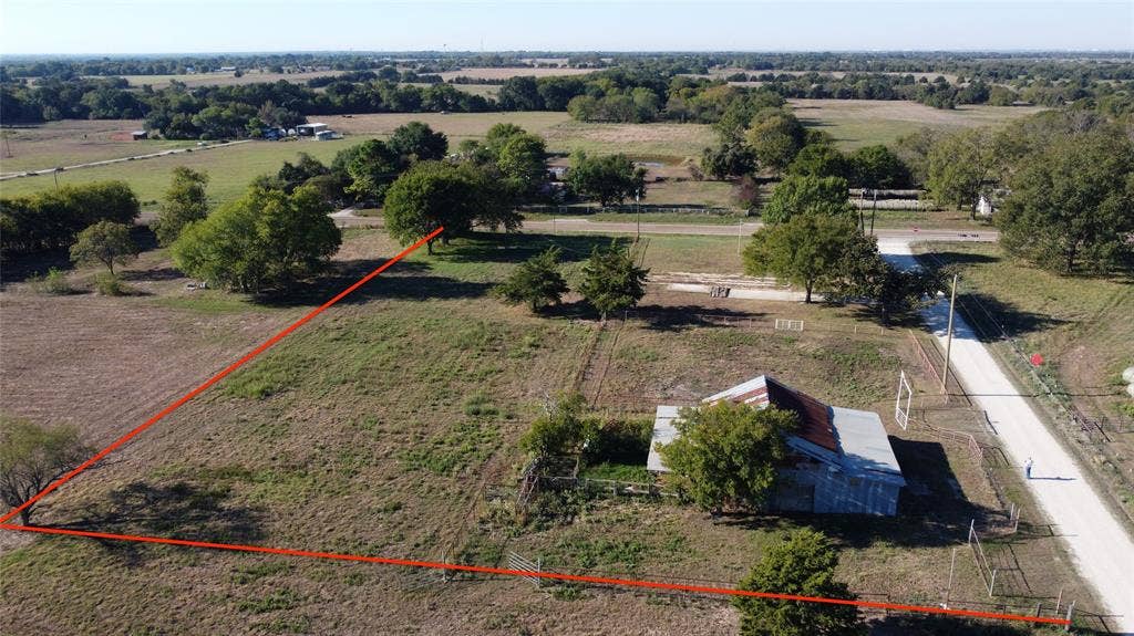 Expansive acreage featuring mature trees, open pasture, and direct road access