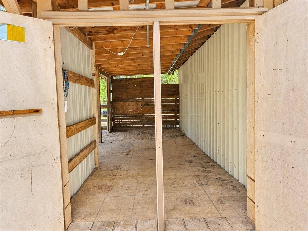 13672 County Road 2915, Eustace, TX 75124 Covered exterior structure featuring corrugated metal siding, exposed timber framing, plywood flooring, and horizontal wood-slat wall panels