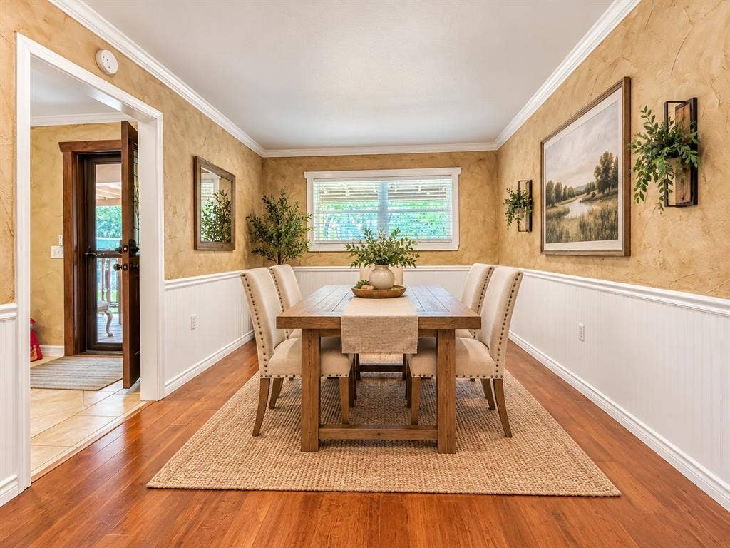 13672 County Road 2915, Eustace, TX 75124 Dining room featuring wood-finish flooring, two-toned walls with beadboard wainscoting, crown molding, and a single-hung window
