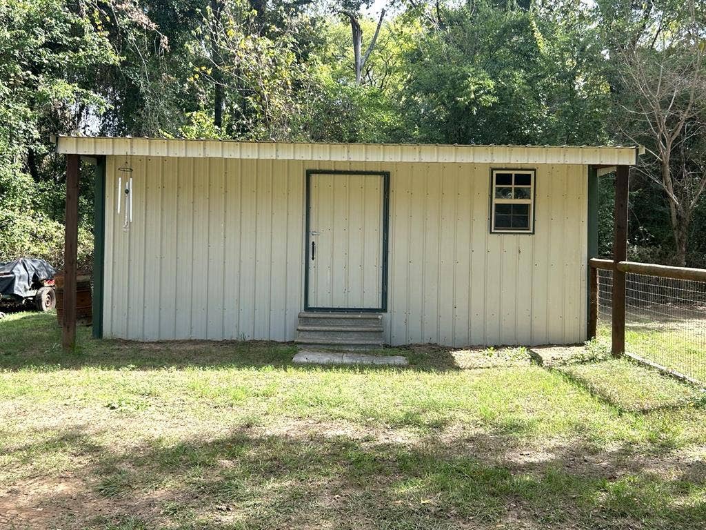 13672 County Road 2915, Eustace, TX 75124 Detached exterior structure featuring metal siding, a single-pane grid window, a central entry door, and concrete step