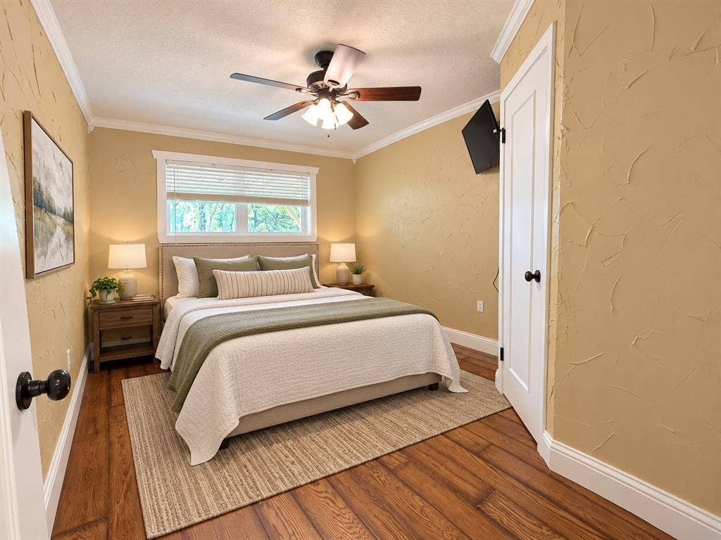 13672 County Road 2915, Eustace, TX 75124 Wood-finish flooring, textured wall finishes, crown molding, a single-hung window with blinds, and a central ceiling fan with integrated lighting