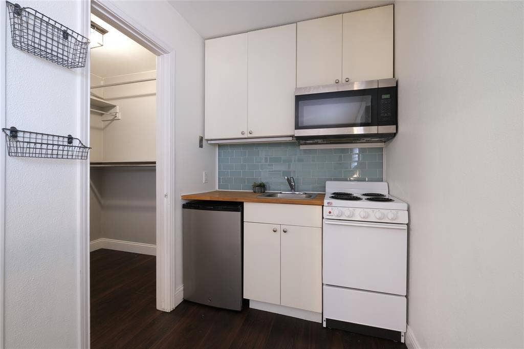 514 E Spring Valley Road, Richardson, TX 75081 Kitchen equipped with dishwasher, oven, range, microwave, and full size refrigerator will be made available downstairs. Baskets installed on wall for additional storage