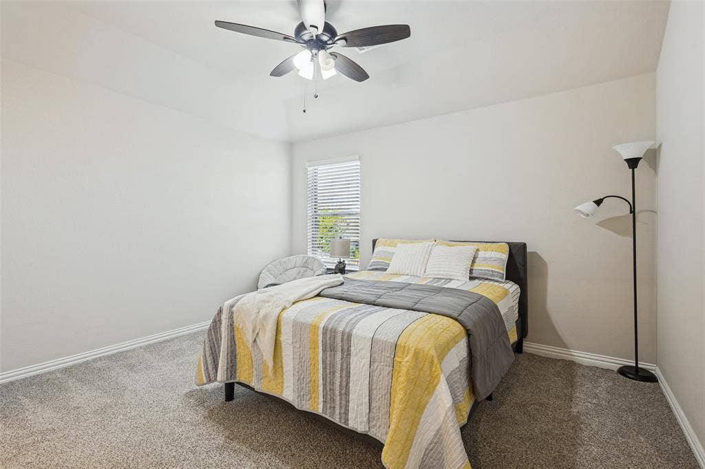5313 Pratt Circle, McKinney, TX 75071 Neutral wall color, wall-to-wall carpeting, window with slatted blinds, and ceiling fan with integrated lighting