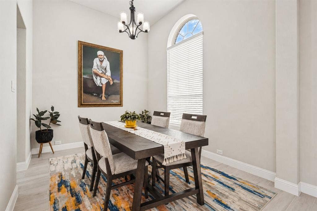 5313 Pratt Circle, McKinney, TX 75071 High ceilings featuring an arched window, wood-finish flooring, and a decorative chandelier