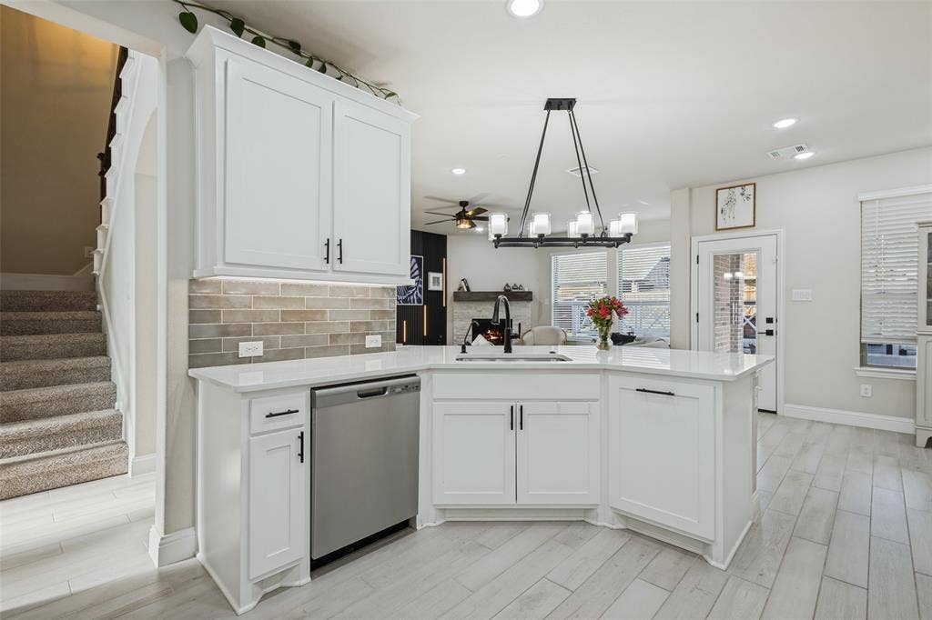 5313 Pratt Circle, McKinney, TX 75071 Kitchen featuring white shaker-style cabinetry, white countertops, a tiled backsplash, wood-finish flooring, and a multi-light chandelier