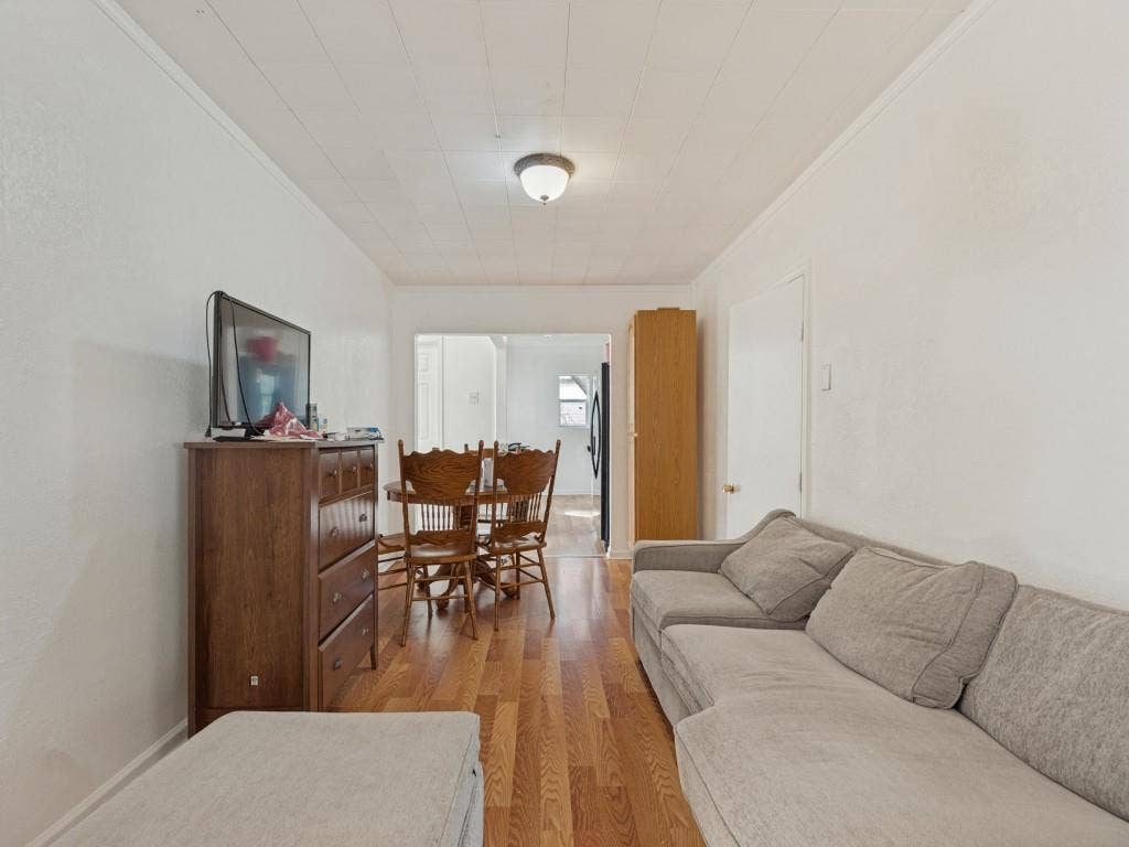 2009 Pecan Street, Commerce, TX 75428 Wood-finish flooring, white walls, and a ceiling-mounted light fixture