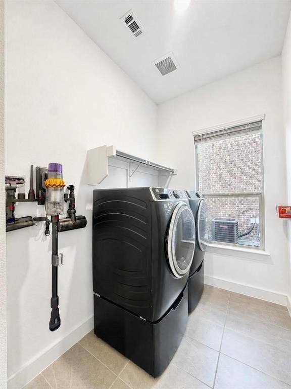 8912 Free Ferry Lane, McKinney, TX 75071 Laundry area featuring large-format tile flooring, a window with natural light, and wall-mounted shelving