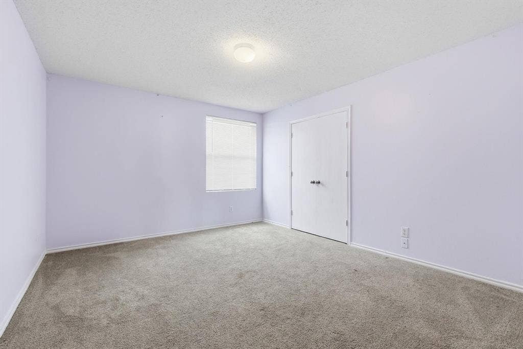 1633 Sierra Meadow Lane, Fort Worth, TX 76247 Interior room featuring wall-to-wall carpeting, a dual-door closet, a single-pane window with integrated blinds, and a central ceiling-mounted light fixture
