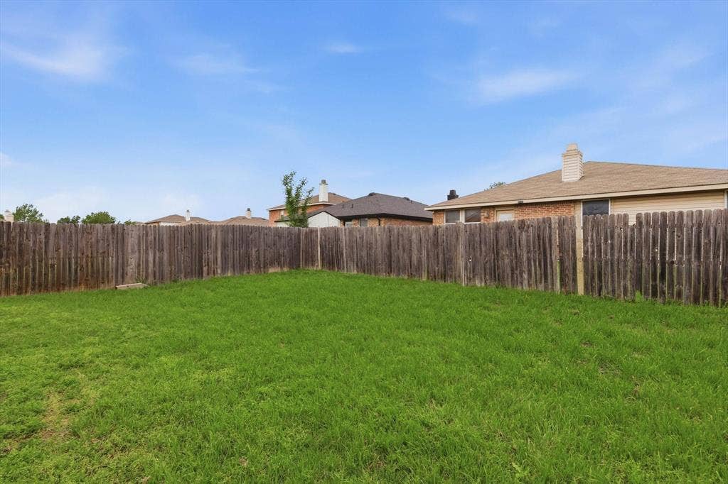 1633 Sierra Meadow Lane, Fort Worth, TX 76247 Backyard featuring a manicured lawn and perimeter wood fencing